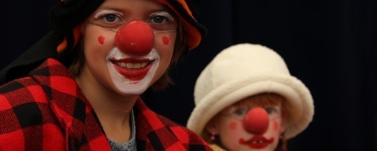 Zwei Circuskinder als Clowns mit roten Nasen