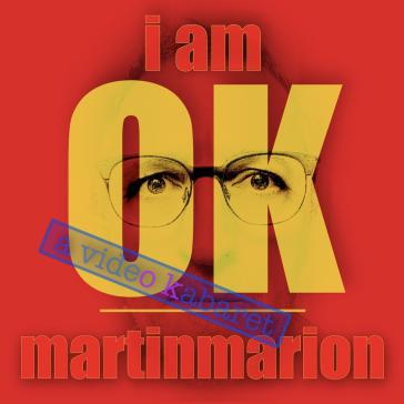 Das Bild hat einen roten Hintergrund mit dem Text "i am OK" in großen gelben Buchstaben. Hinter dem Text sind Augen und eine Brille sichtbar, was dem Bild eine persönliche Note verleiht. Unten steht "martinmarion" und der blaue Stempel "a video kabaret" fügt ein kreatives Element hinzu. Die Gestaltung wirkt modern und ausdrucksstark.