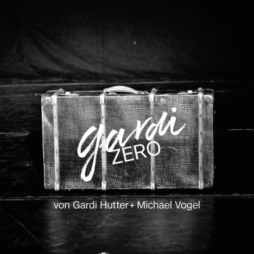 Ein alter Koffer mit Lederstruktur steht auf einer dunklen Bühne. Darauf steht in weißer Schrift „gardi ZERO“. Unten steht: „von Gardi Hutter + Michael Vogel“.