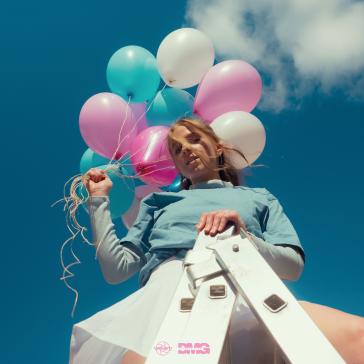 Person lehnt an einer Leiter, hält bunte Luftballons in Rosa, Türkis und Weiß, trägt ein hellblaues Oberteil und wirkt entspannt bei blauem Himmel mit Wolken.