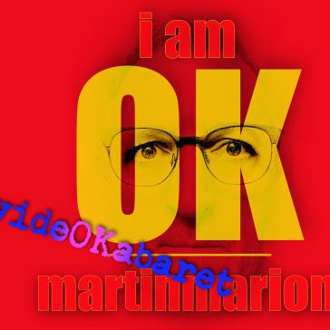Porträt mit Brille, überlagert von gelben Buchstaben ‚I AM OK‘ und blauen Schriftzügen ‚Video Kabaret Martinmarion‘ auf rotem Hintergrund.