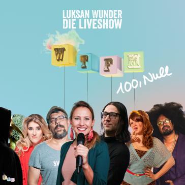 Gruppenfoto der Live-Show ‚Luksan Wunder‘: Sieben lächelnde Personen vor türkisem Hintergrund, Text ‚WTFM 100, Null‘ und bunte Würfel mit Buchstaben, Frau mit Mikrofon in der Mitte.