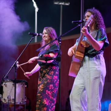 Zwei Frauen singend auf der Bühne. Eine Frau mit Gitarre und eine Frau mit einer Trommel
