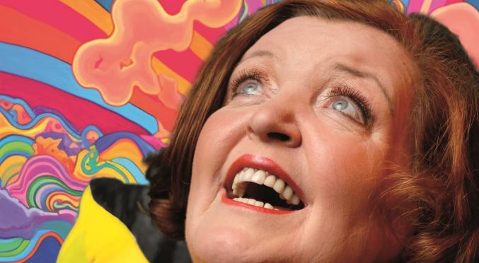 Lachende Frau mit roten Haaren, Blick nach oben, vor psychedelischem Hintergrund mit Regenbogenfarben, Wolken und verspielt-wellenförmigen Mustern.