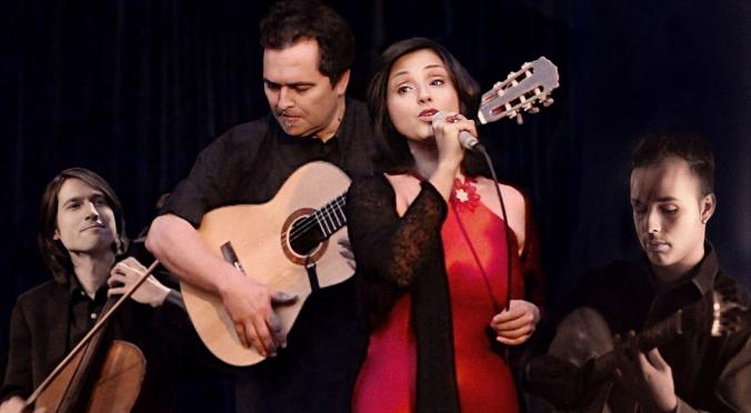 Vier Musiker auf der Bühne: Links Geiger, Mitte Gitarrist, Sängerin in rotem Kleid mit Mikrofon, rechts Schlagzeuger, alle konzentriert und in schwarzer Kleidung, dunkler Hintergrund.