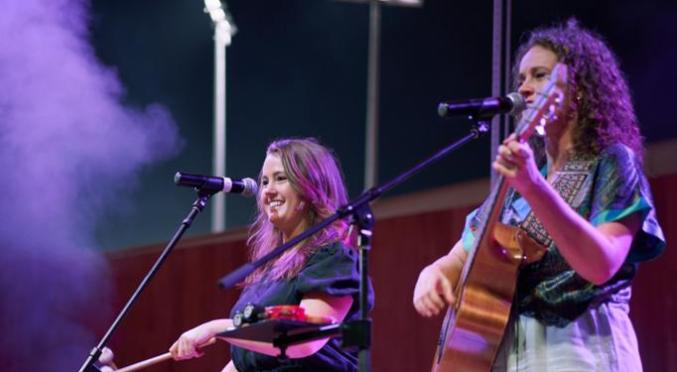 Zwei Frauen singend auf der Bühne. Eine Frau mit Gitarre und eine Frau mit einer Trommel